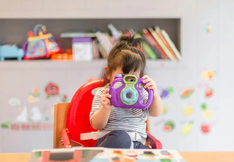 Criança pequena brincando em sala colorida